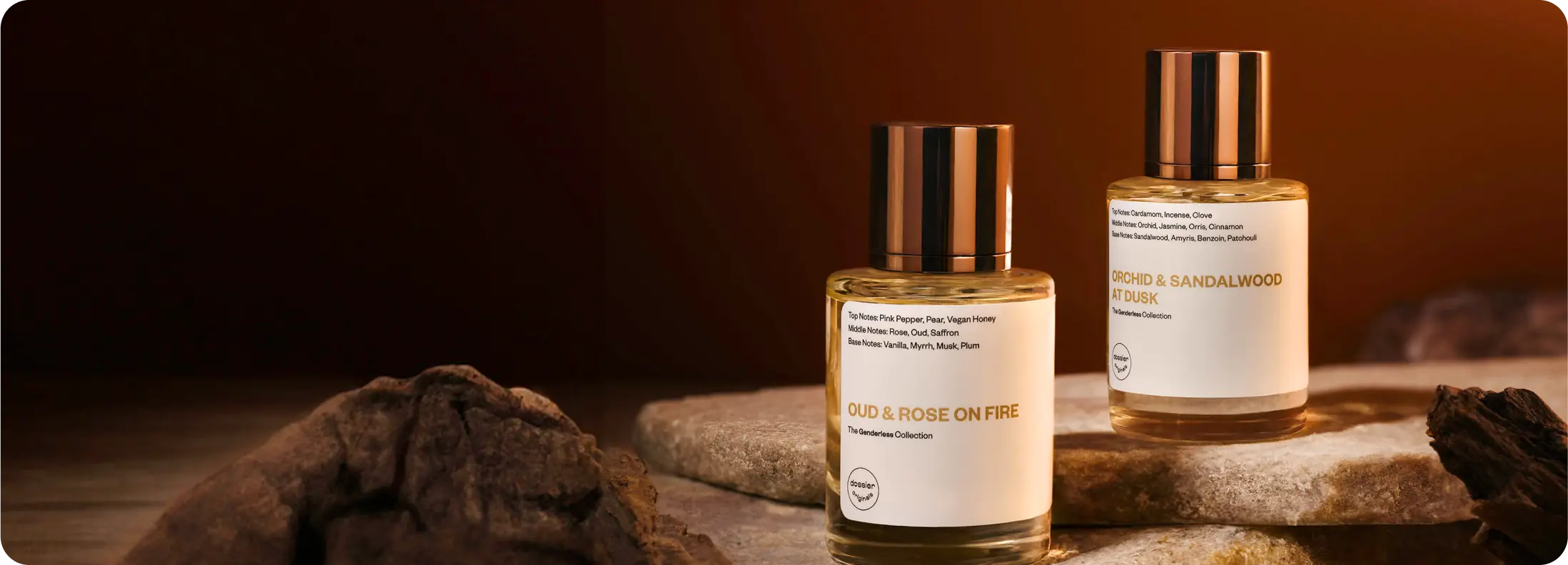 Dossier Oud & Rose on Fire and Orchid & Sandalwood at Dusk perfume bottles displayed on stone surfaces in a warm, moody amber setting.
