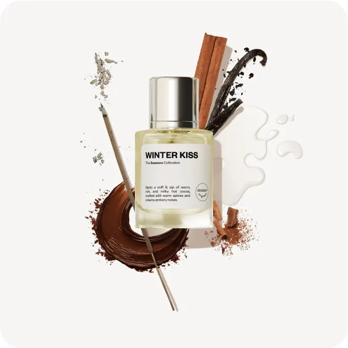 Dossier Winter Kiss perfume bottle surrounded by cinnamon, vanilla, creamy notes, and warm brown accents on a white background.