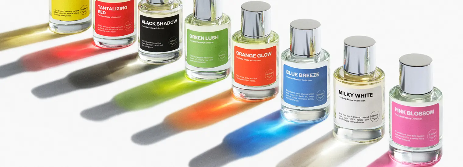 Color Factory perfume bottles with colorful labels casting vibrant rainbow shadows on a white background.