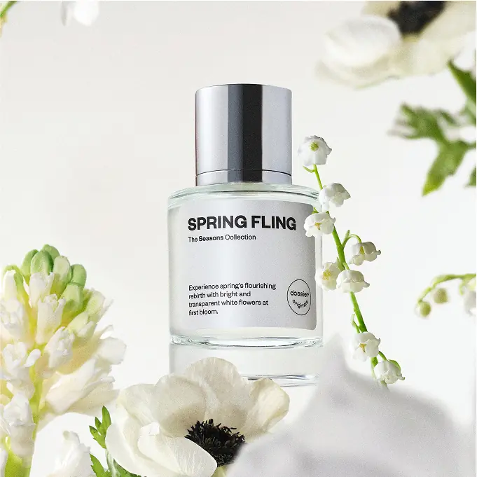 Dossier Spring Fling perfume bottle surrounded by delicate white spring flowers on a bright white background.