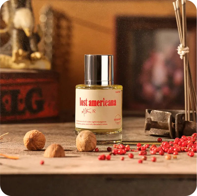 Lost Americana perfume displayed with nutmeg and pink peppercorns in a warm, vintage-inspired setting.