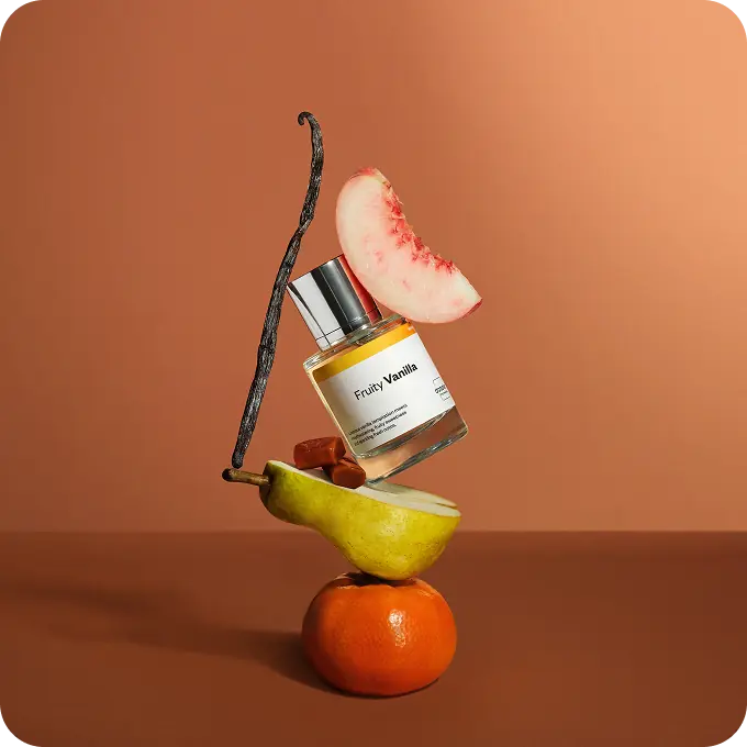 Dossier Fruity Vanilla perfume balanced with a pear, peach slice, vanilla pod, caramel pieces, and an orange.