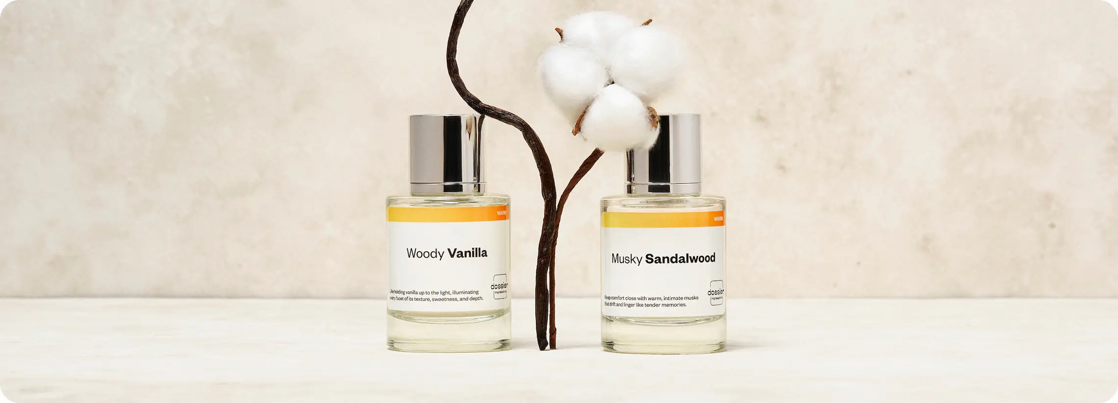 Dossier Woody Vanilla and Musky Sandalwood perfumes displayed with vanilla pods and a cotton flower.